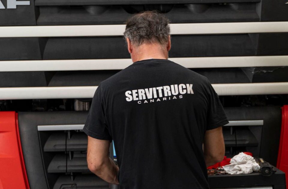 Mecánico de Servitruck Canarias trabajando en el motor de un camión rojo DAF
