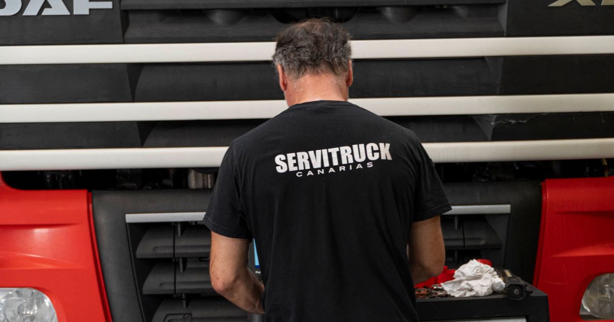Mecánico de Servitruck Canarias trabajando en el motor de un camión rojo DAF