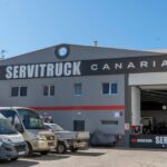Vista exterior de las instalaciones de Servitruck Canarias, mostrando la entrada del taller y vehículos estacionados
