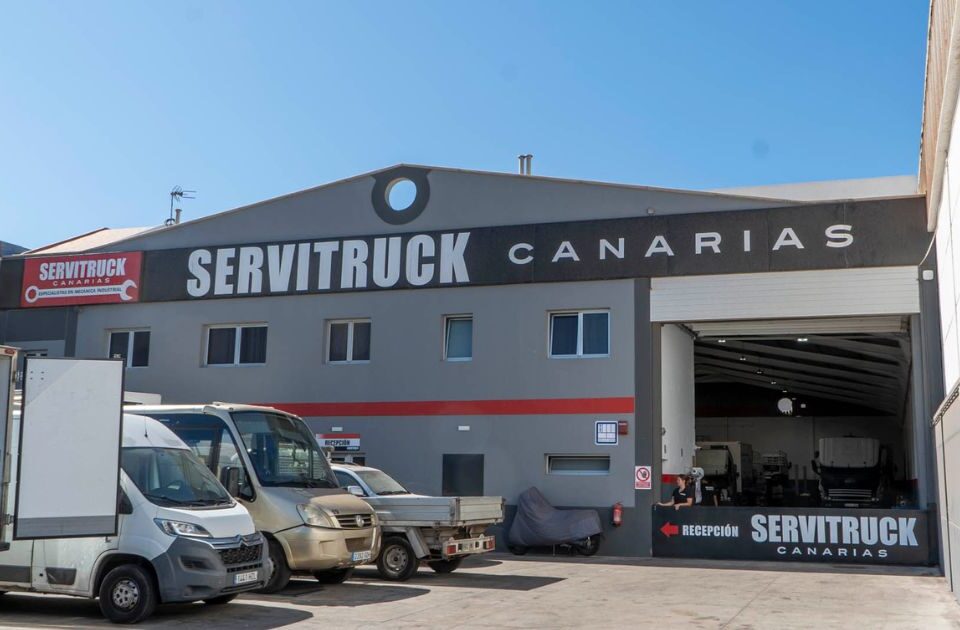 Vista exterior de las instalaciones de Servitruck Canarias, mostrando la entrada del taller y vehículos estacionados
