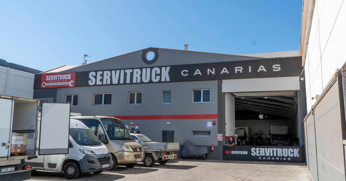 Vista exterior de las instalaciones de Servitruck Canarias, mostrando la entrada del taller y vehículos estacionados