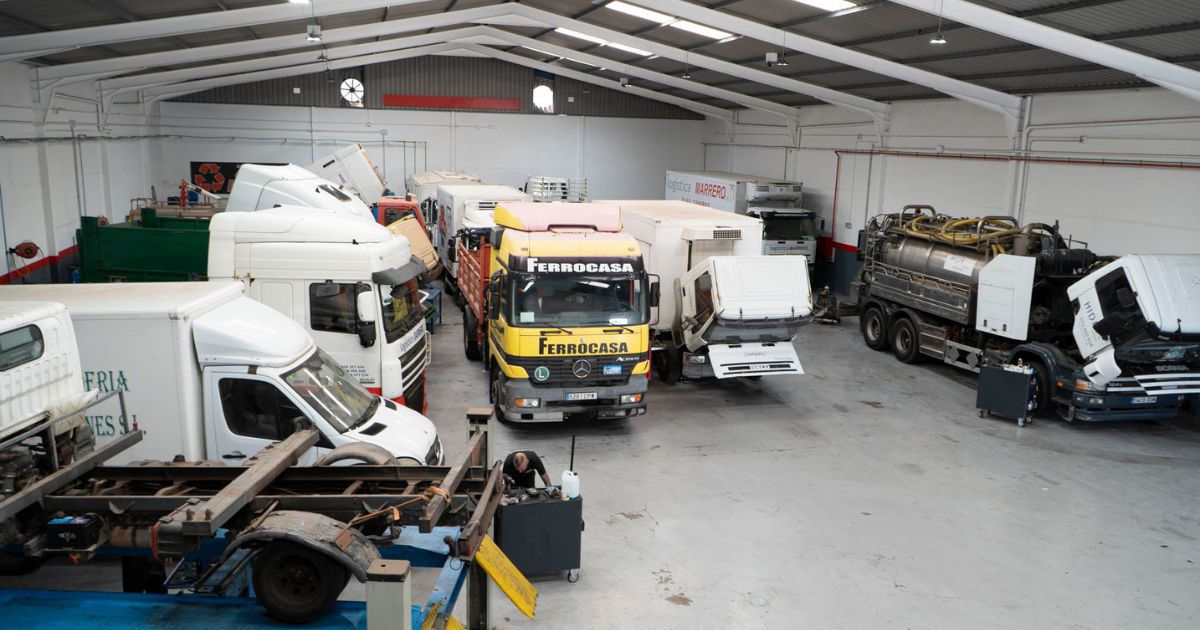 Vista general del taller de Servitruck con varios vehículos industriales en reparación y mantenimiento.